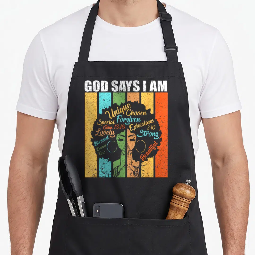 Pride god says i am apron - Retro silhouette of woman with afro over colorful stripes with script bible verses and GOD — shown on a black cotton canvas apron against a white background