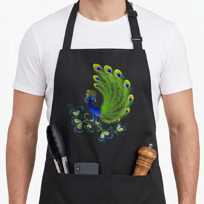 Majestic the floral apron - Realistic peacock facing right with fanned blue green yellow and orange tail feathers — shown on a black cotton canvas apron against a white background