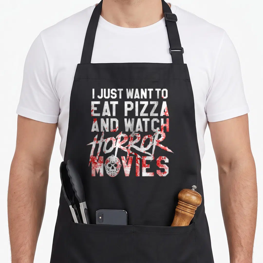 Horror pizza apron - Stacked white text with red splatters and hockey mask inside the letter O of movies — shown on a black cotton canvas apron against a white background