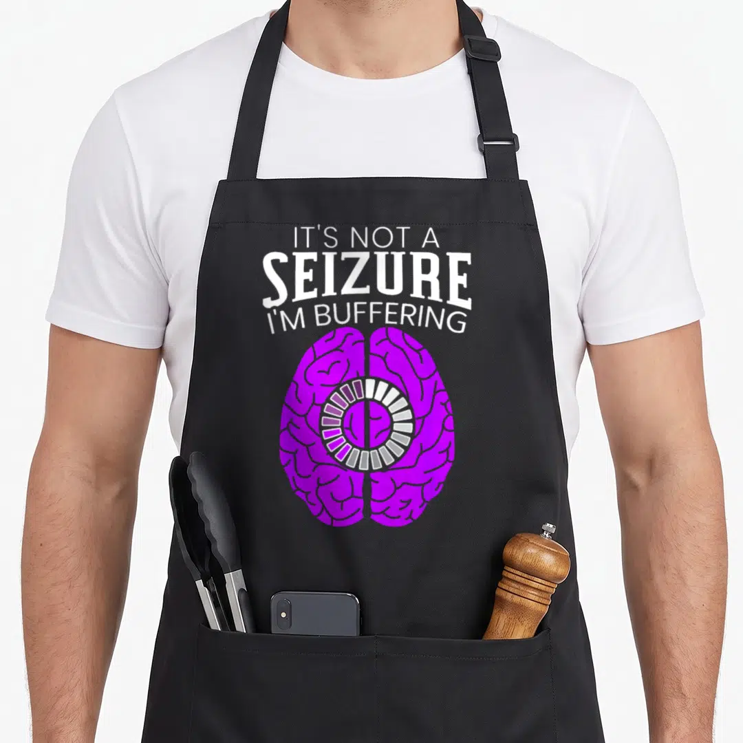 Seizure epilepsy awareness apron - Purple brain with white buffering text and loading circle icon — shown on a black cotton canvas apron against a white background