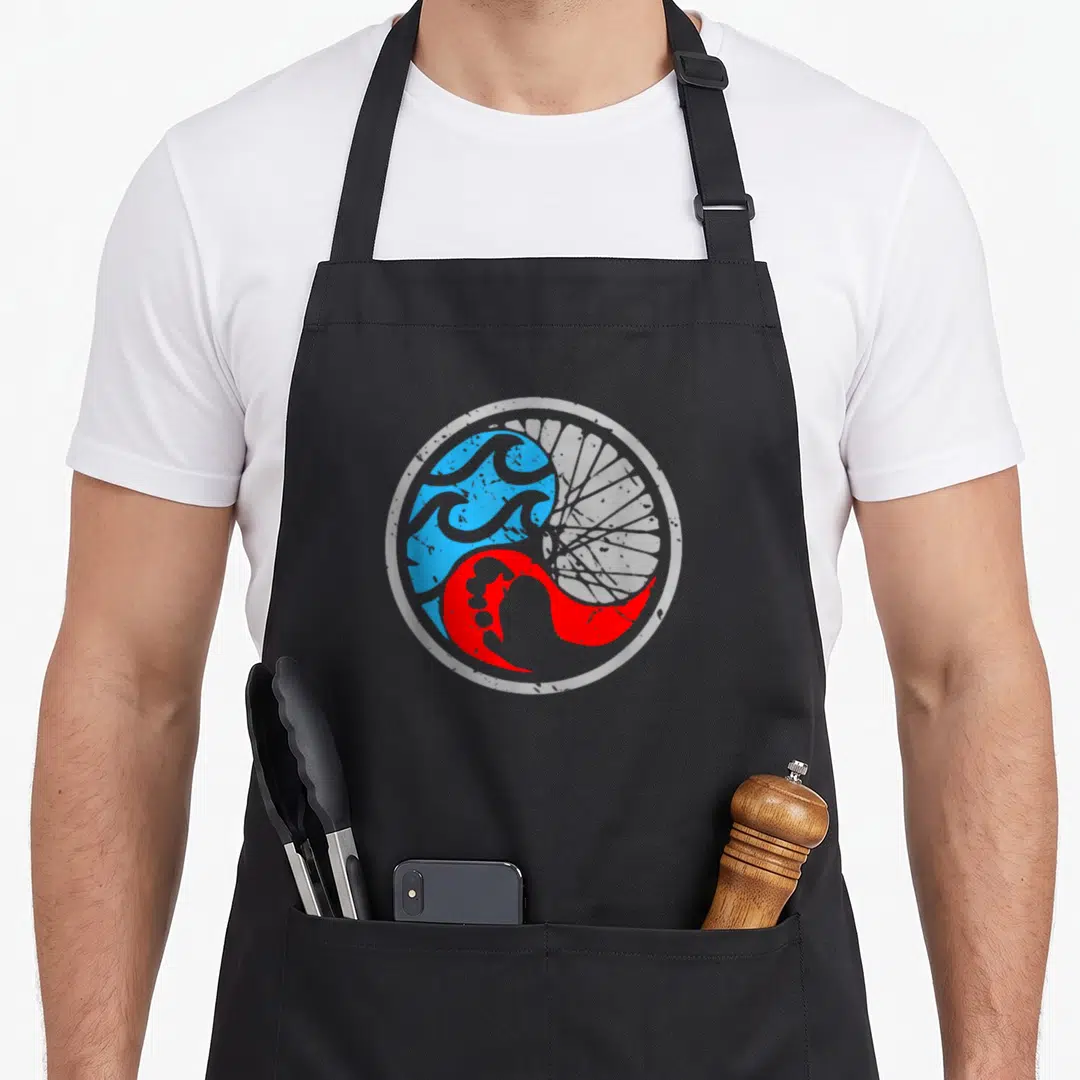 Swim bike apron - Circular yin yang with blue waves and red bike spokes in white border — shown on a black cotton canvas apron against a white background