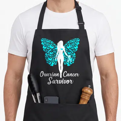 Survivor warrior ribbon apron - White woman silhouette with cyan butterfly wings and Ovarian Cancer Survivor text — shown on a black cotton canvas apron against a white background
