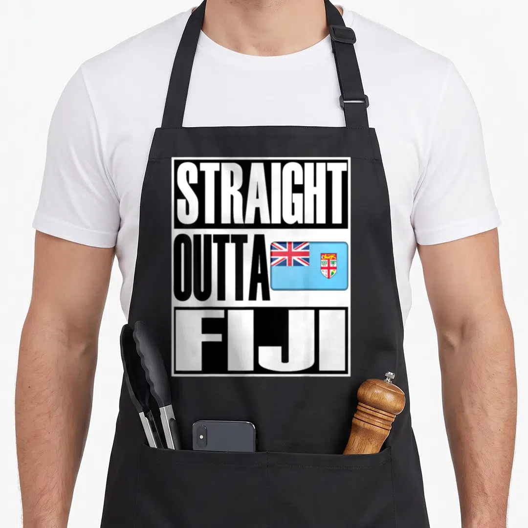 Outta pride apron - Stacked STRAIGHT OUTTA FIJI text with light blue flag on black background — shown on a black cotton canvas apron against a white background