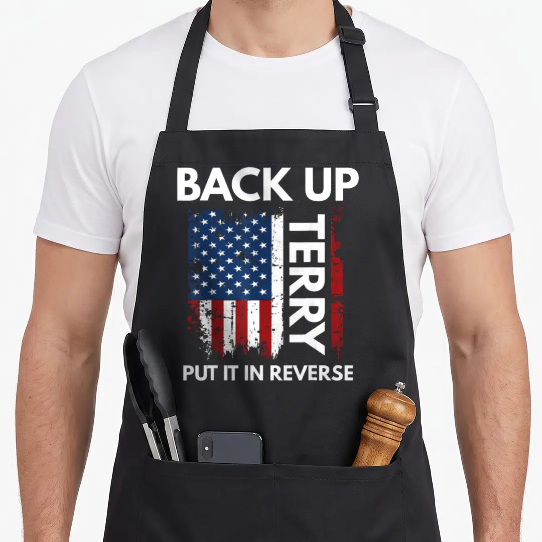 Reverse 4th of july apron - Distressed USA flag with BACK UP TERRY PUT IT IN REVERSE text — shown on a black cotton canvas apron against a white background