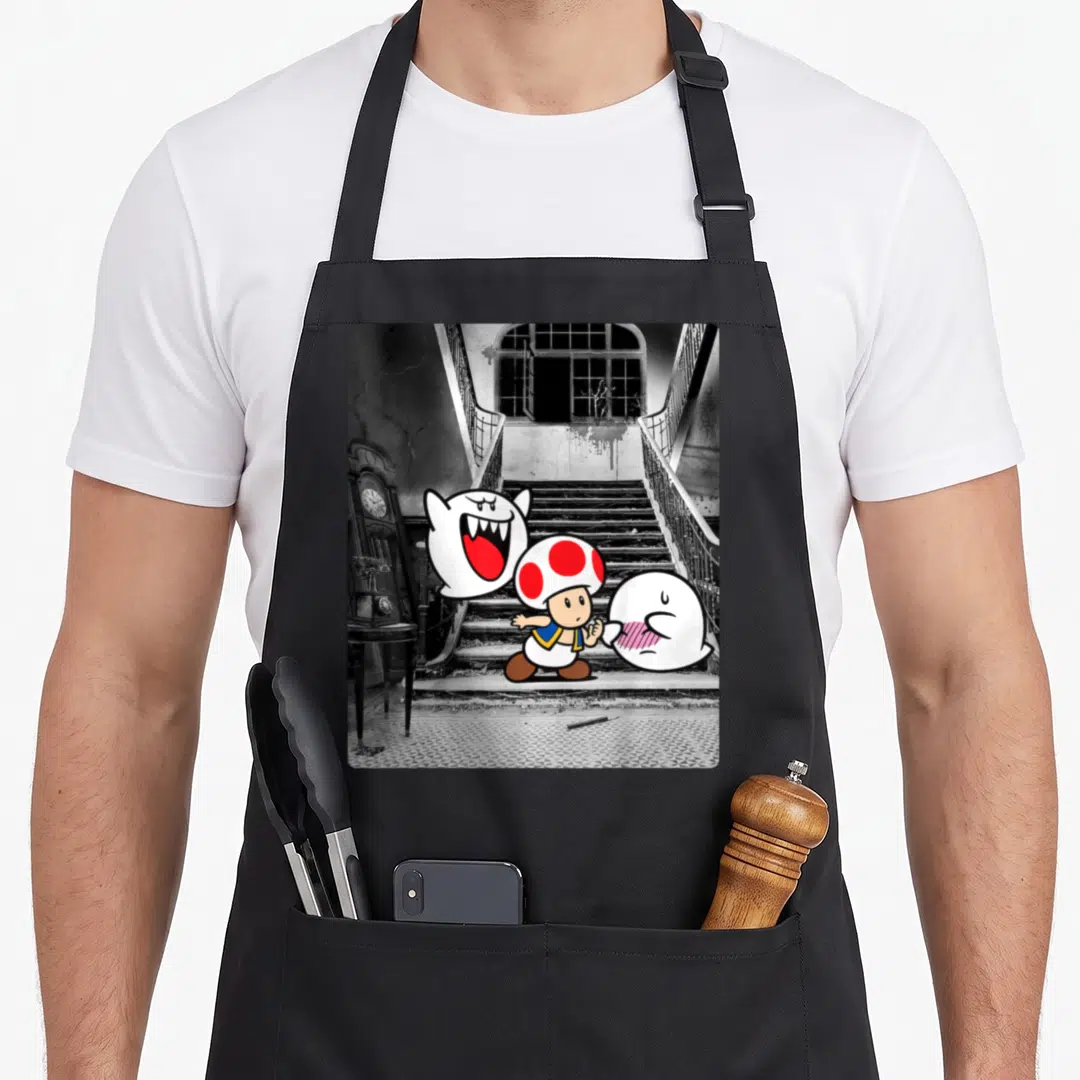 Toad haunted mansion apron - Toad and two ghosts on a black and white photo of stairs and a clock — shown on a black cotton canvas apron against a white background