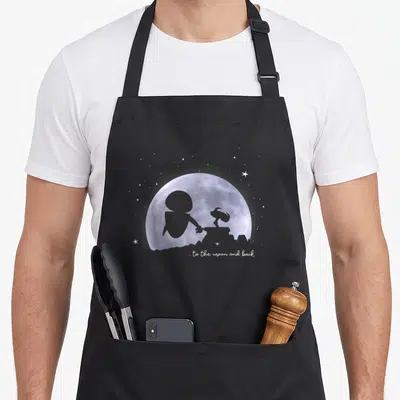 Moon e.a apron - Purple watercolor moon with grey astronaut and rover silhouettes and white text ... to the moon — shown on a black cotton canvas apron against a white background
