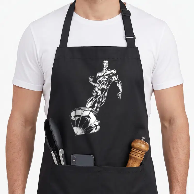 Comic full body apron - White line art of Silver Surfer standing on a surfboard in a diagonal pose — shown on a black cotton canvas apron against a white background