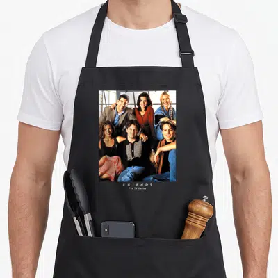 Early friends apron - Photo of six people with stacked F R I E N D S The TV Series text below — shown on a black cotton canvas apron against a white background