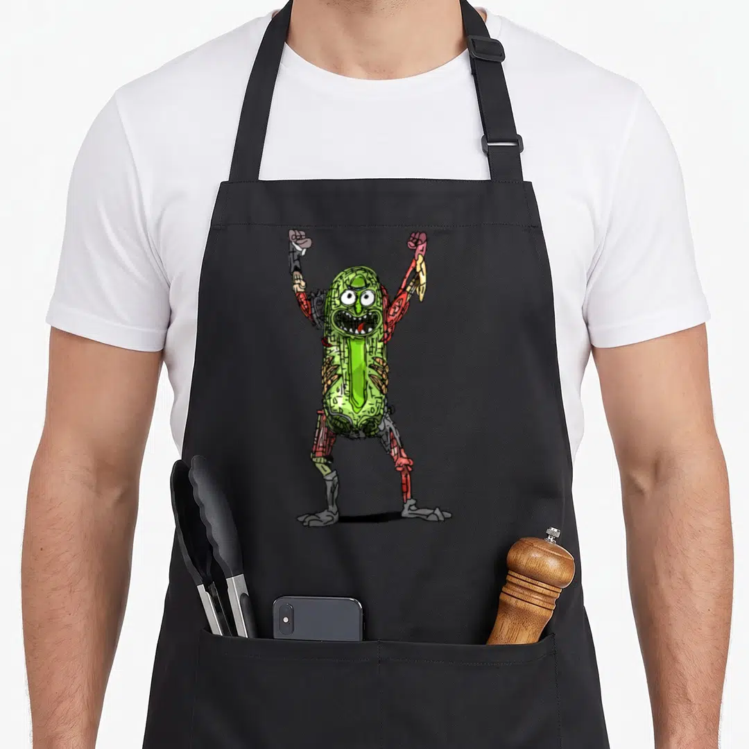 Pop pickle apron - Green pickle with red and grey robotic limbs standing with arms raised — shown on a black cotton canvas apron against a white background
