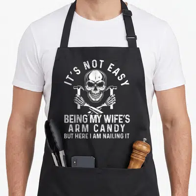 Easy wife father day apron - White skull with crossed skeleton arms holding hammers and distressed text — shown on a black cotton canvas apron against a white background