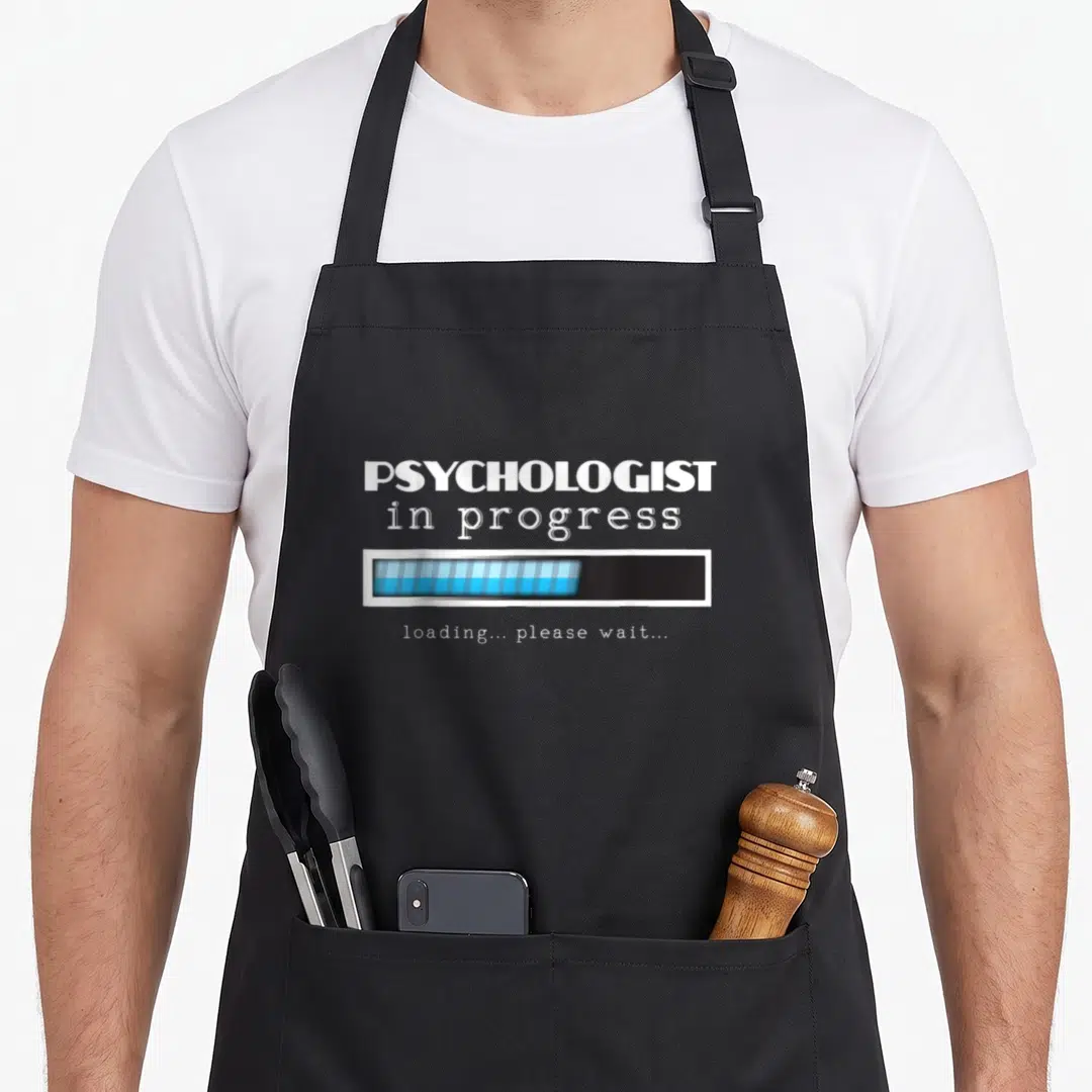 Psyd student aprons - PSYCHOLOGIST in progress text with blue loading bar graphic — shown on a black cotton canvas apron against a white background