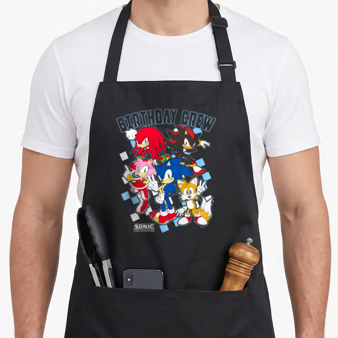 Cre birthday apron - Sonic crew BIRTHDAY CREW text five characters blue checkered pattern group shot — shown on a black cotton canvas apron against a white background