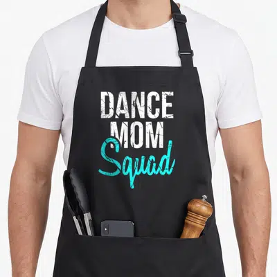 Dance my mother's apron - DANCE MOM Squad text in white and teal distressed typography — shown on a black cotton canvas apron against a white background