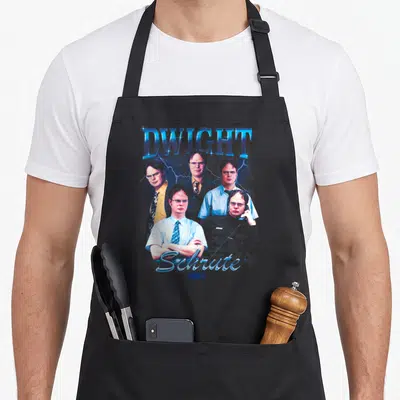 Dwight nbc apron - Five retro portraits of Dwight Schrute with lightning bolts and blue red grey colors — shown on a black cotton canvas apron against a white background
