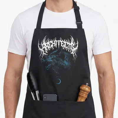 Wolf architect apron - Blue wolf head under white stylized ARCHITECTS text with four crosses and crescent moon — shown on a black cotton canvas apron against a white background
