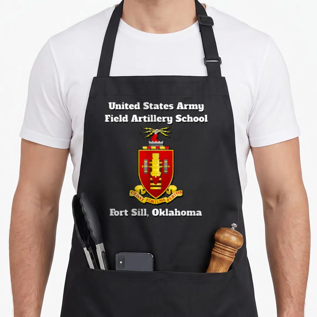 Artillery field apron - Red gold and black Field Artillery School crest with lightning bolt and cannon shield on black — shown on a black cotton canvas apron against a white background