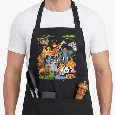 Wildlife animal apron - Cartoon cluster of 22 zoo animals including tiger, elephant, giraffe, sloth, and koala framed — shown on a black cotton canvas apron against a white background