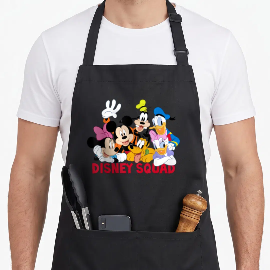 Squad friends apron - Cluster of cartoon characters above red DISNEY SQUAD text — shown on a black cotton canvas apron against a white background