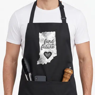 Fund teacher apron - Distressed white Indiana map shape with fund OUR future text and grey heart — shown on a black cotton canvas apron against a white background