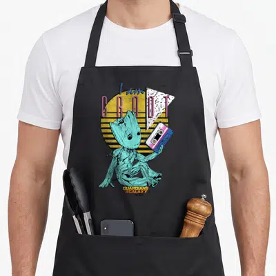 Guardian 90s apron - Teal Groot holding blue cassette tape with I am GROOT AWESOME MIX vol 2 text — shown on a black cotton canvas apron against a white background