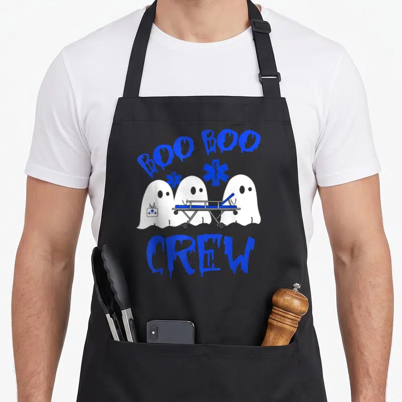 Ems halloween nurse apron - Three white ghosts holding stretcher and kit under blue BOO BOO CREW text with Star of Life — shown on a black cotton canvas apron against a white background