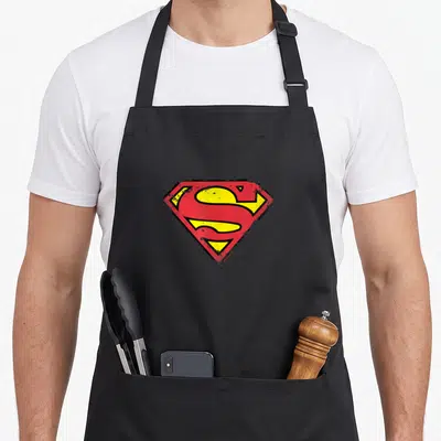 Shield distressed apron - Red and yellow distressed S-shield logo on black fabric — shown on a black cotton canvas apron against a white background