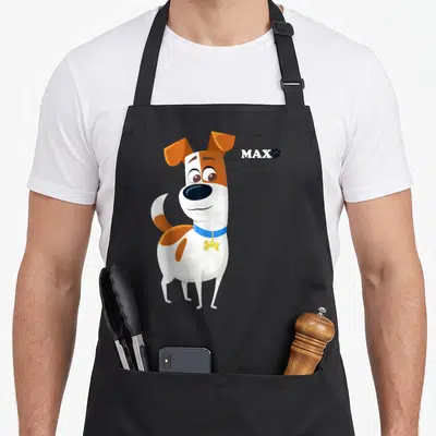 Max pet apron - Cartoon white and orange dog with blue collar, yellow tag, and MAX text with paw print — shown on a black cotton canvas apron against a white background