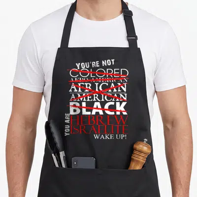 Wake hebrew aprons - Stacked text crossing out racial labels in red to declare Hebrew Israelite identity — shown on a black cotton canvas apron against a white background