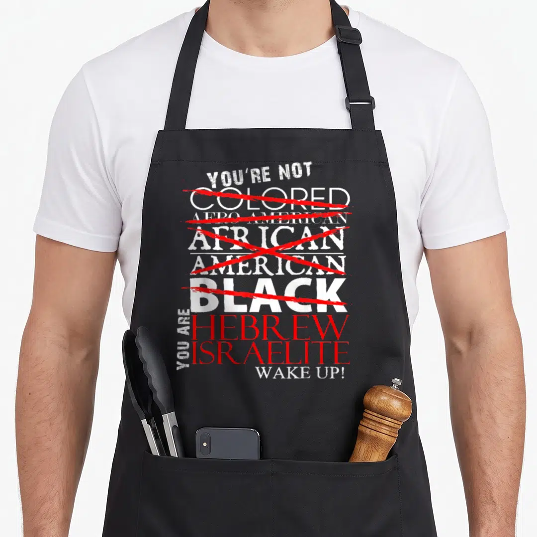Wake hebrew aprons - Stacked text crossing out racial labels in red to declare Hebrew Israelite identity — shown on a black cotton canvas apron against a white background