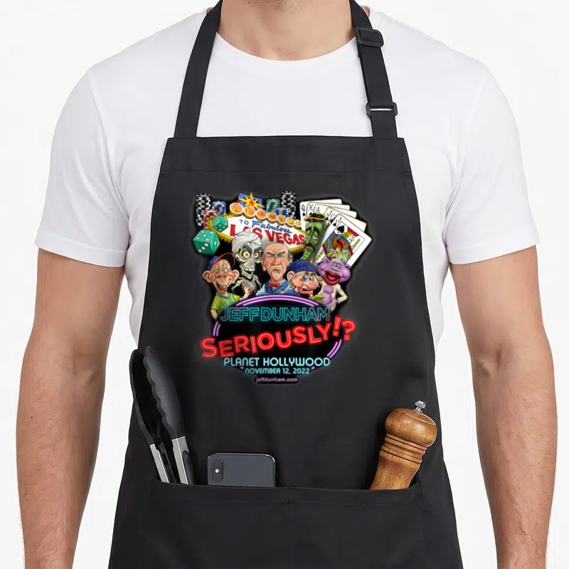 Planet hollywood apron - Jeff Dunham puppets and Las Vegas sign with neon text on black apron — shown on a black cotton canvas apron against a white background