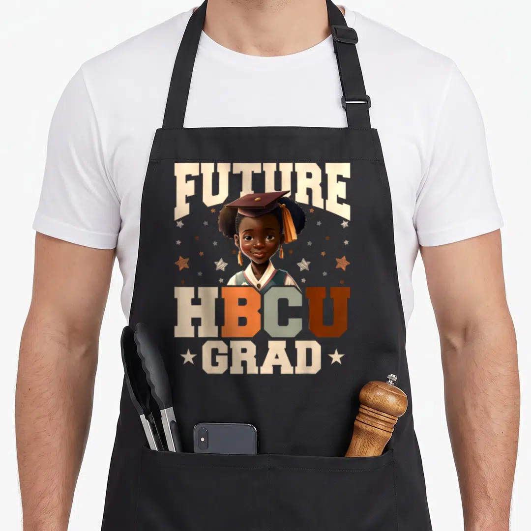 Youth future history apron - Cartoon girl in cap with FUTURE HBCU GRAD text and stars — shown on a black cotton canvas apron against a white background