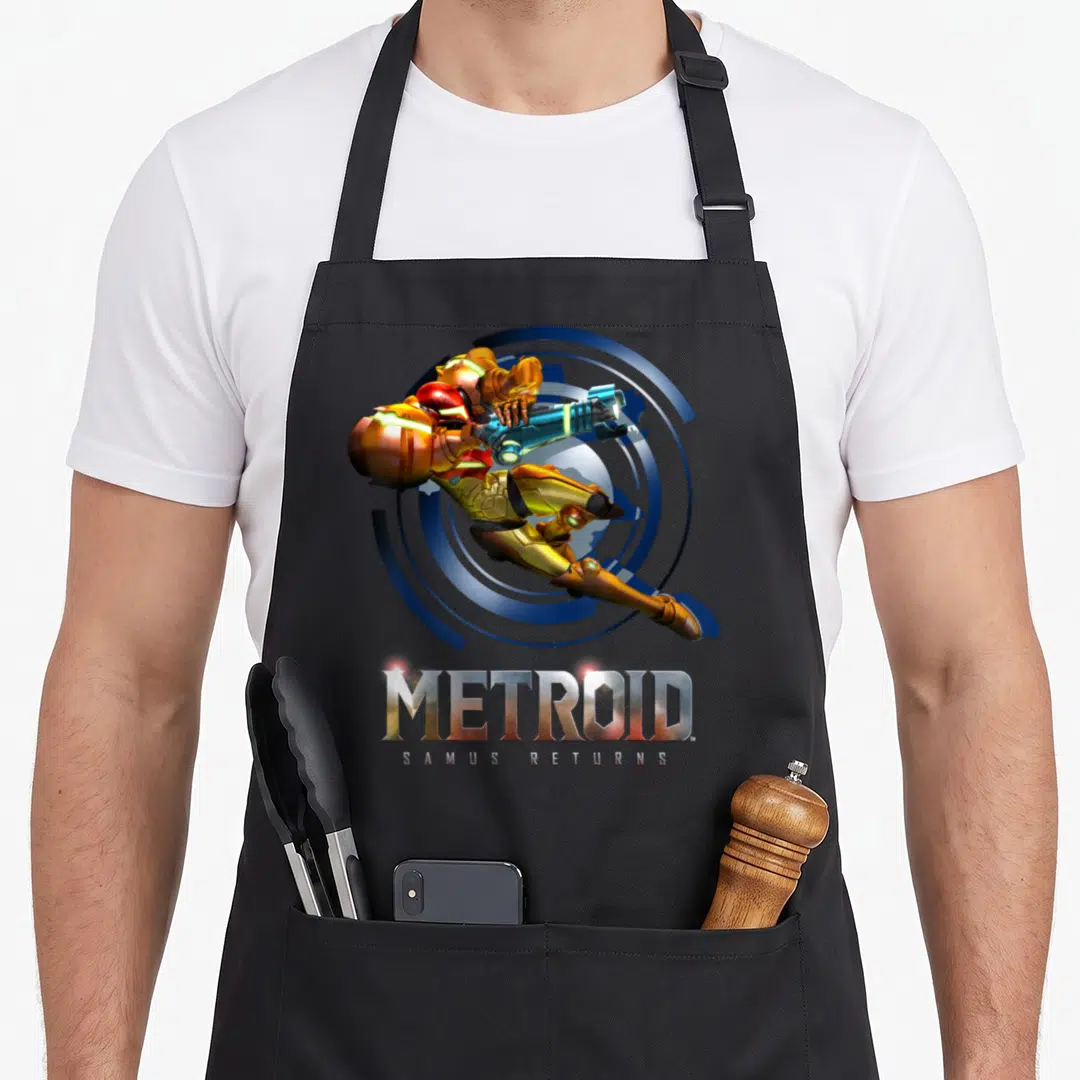Jump metroidvania apron - Leaping Samus Aran in orange gold armor with metallic METROID and SAMUS RETURNS text below — shown on a black cotton canvas apron against a white background