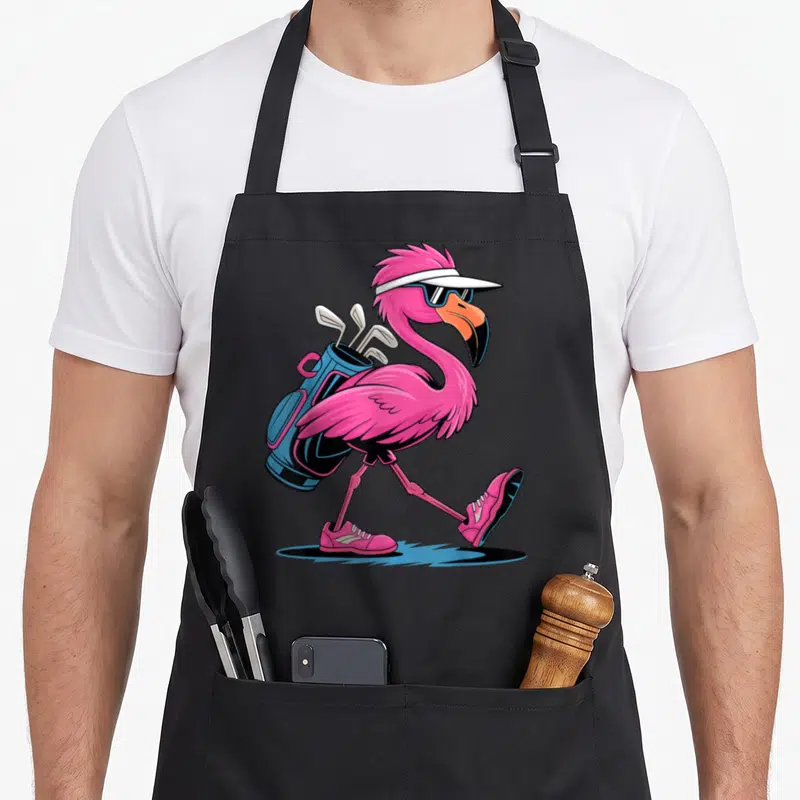 Ping golf apron - Pink flamingo walking with blue golf bag, white visor, and sunglasses — shown on a black cotton canvas apron against a white background