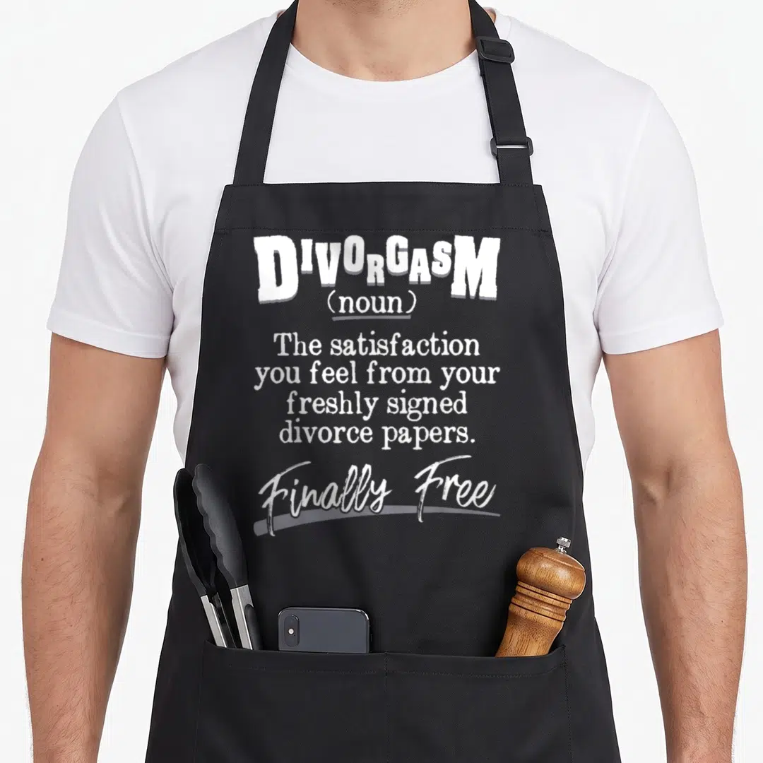 Divorgam divorce party apron - White typography reading DIVORGASM definition and Finally Free on grey background — shown on a black cotton canvas apron against a white background