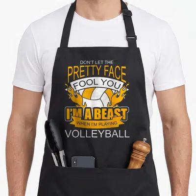 Volleyball pull girl apron - Yellow white volleyball with flames and sarcastic beast quote text — shown on a black cotton canvas apron against a white background