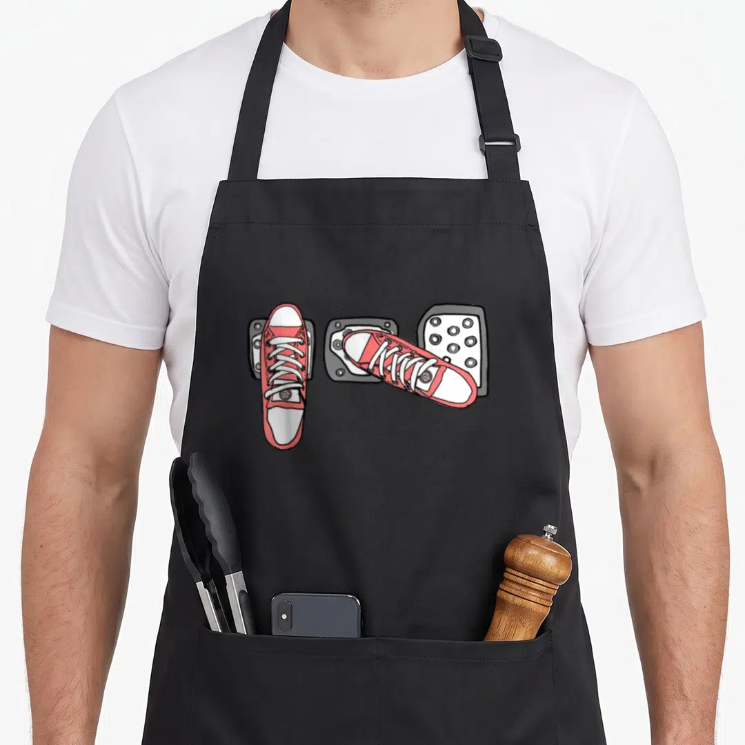 Stick car apron - Two red sneakers on three white soles in cartoon style — shown on a black cotton canvas apron against a white background