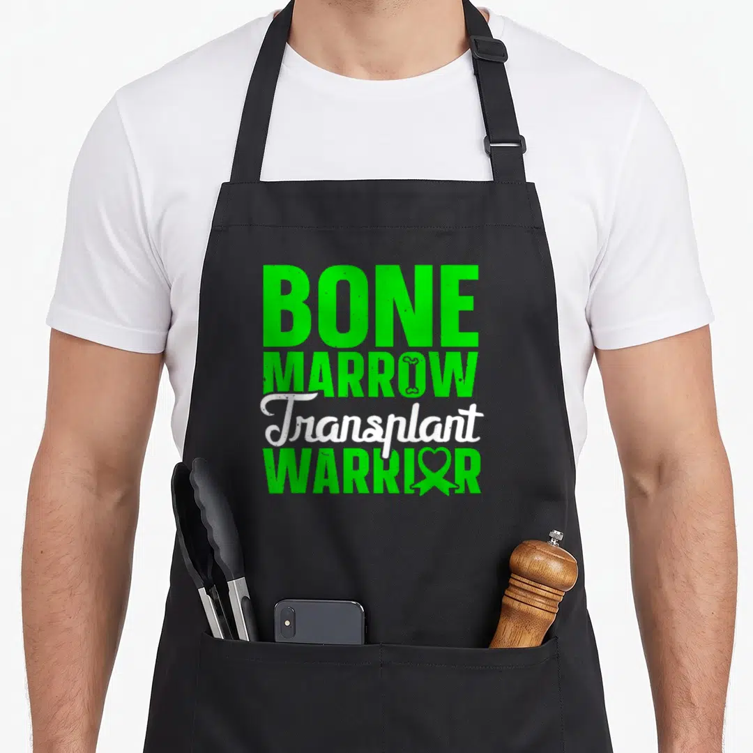 Bone organ apron - Green and white text reading BONE MARROW Transplant WARRIOR with bone and ribbon symbols — shown on a black cotton canvas apron against a white background