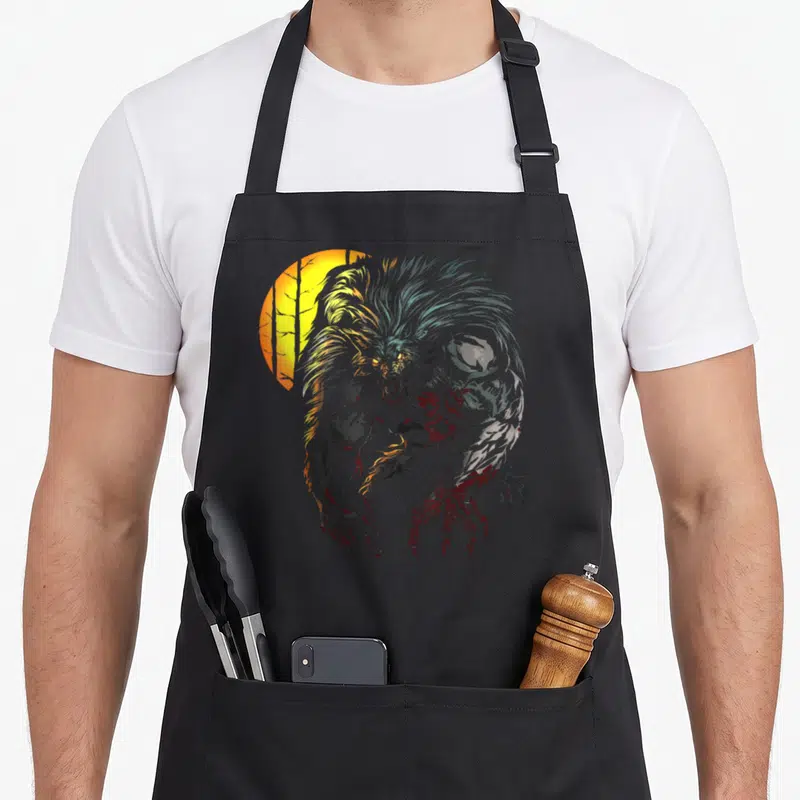 Lycan halloween apron - Realistic grey werewolf with red claws in front of a yellow sun and tree silhouettes — shown on a black cotton canvas apron against a white background