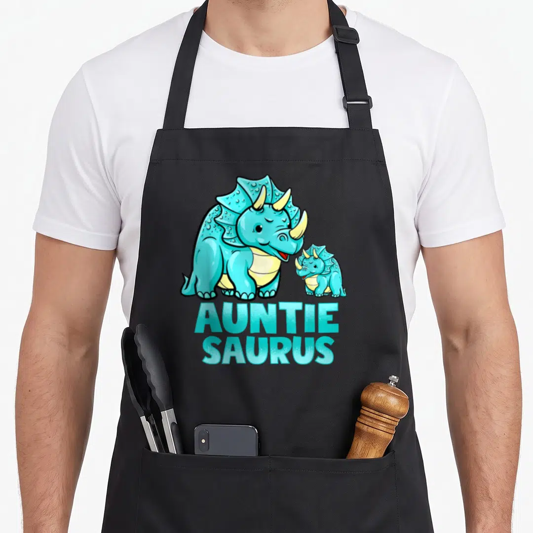 Auntie saurus dinosaur apron - Two blue triceratops above stacked teal Auntie Saurus text in cartoon style — shown on a black cotton canvas apron against a white background