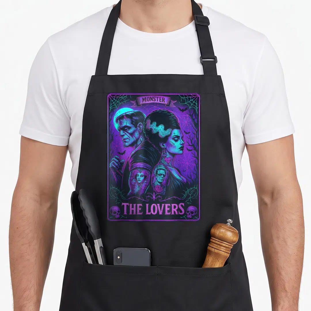 Tarot bride apron - Retro tarot card art with monsters back-to-back, purple and blue, skulls, spider webs, MONSTER — shown on a black cotton canvas apron against a white background