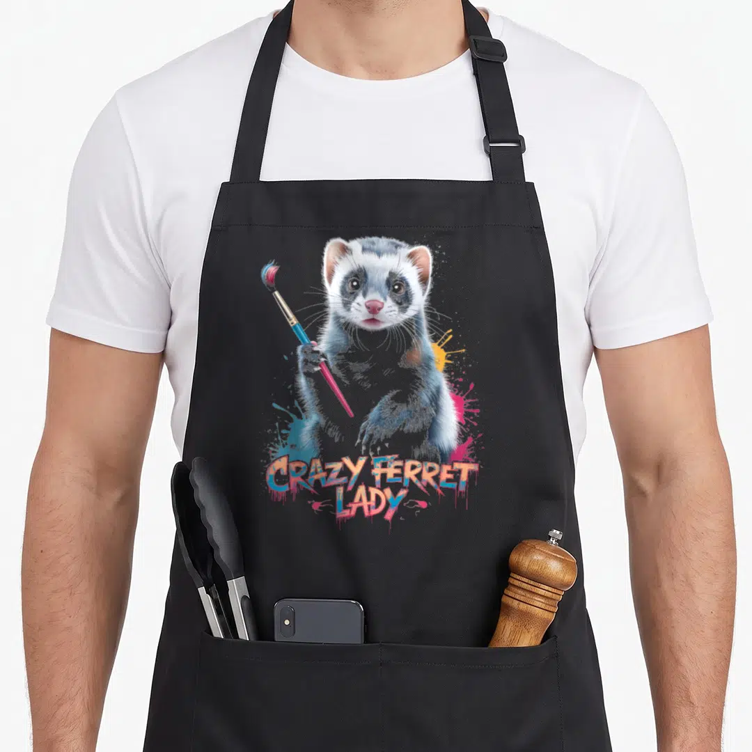 Funny ferret colorful aprons - Realistic ferret holding paintbrush with colorful splatters and graffiti text — shown on a black cotton canvas apron against a white background