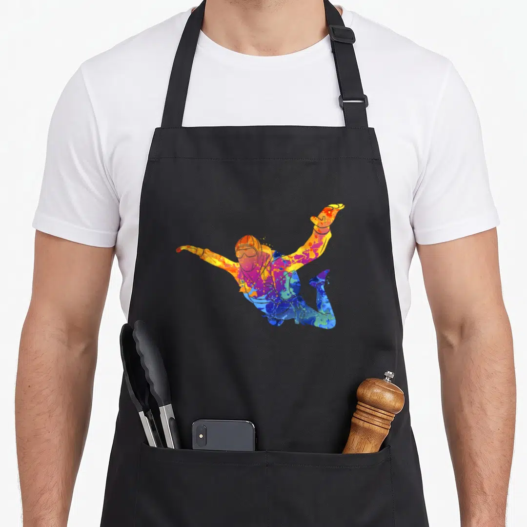 Parachutust skydiving apron - Multicolored watercolor skydiver figure in jumping pose with blue purple orange yellow — shown on a black cotton canvas apron against a white background
