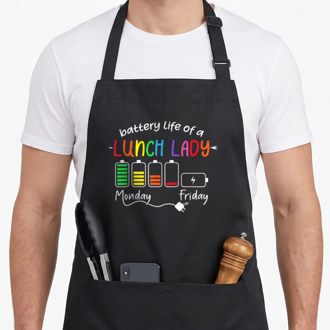 School battery cafeteria aprons - Battery life of a lunch lady text with five colorful battery icons showing energy — shown on a black cotton canvas apron against a white background