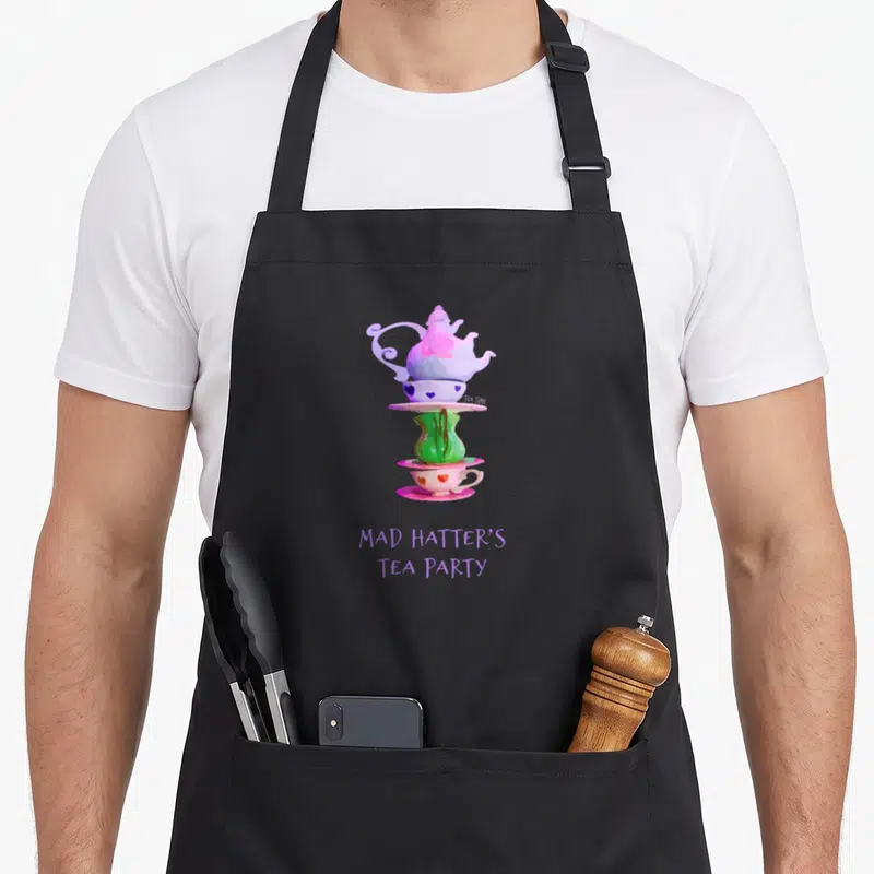 Mad tea party aprons - Stacked purple teapot and pink cup with hearts and purple Mad Hatter's Tea Party text — shown on a black cotton canvas apron against a white background