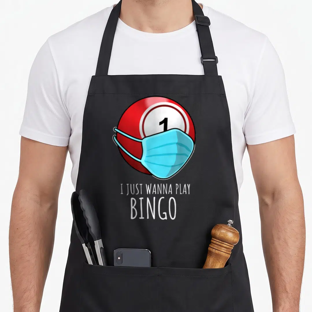 Play player bingo apron - Red bingo ball with blue mask and text I Just Wanna Play Bingo — shown on a black cotton canvas apron against a white background