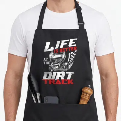Dirt racing race track apron - Sprint car and checkered flag with LIFE IS BETTER AT THE DIRT TRACK text in distressed — shown on a black cotton canvas apron against a white background