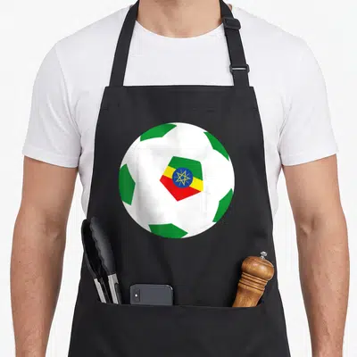 Ethiopia football apron - Soccer ball with green pentagons and Ethiopian flag in red yellow blue center — shown on a black cotton canvas apron against a white background