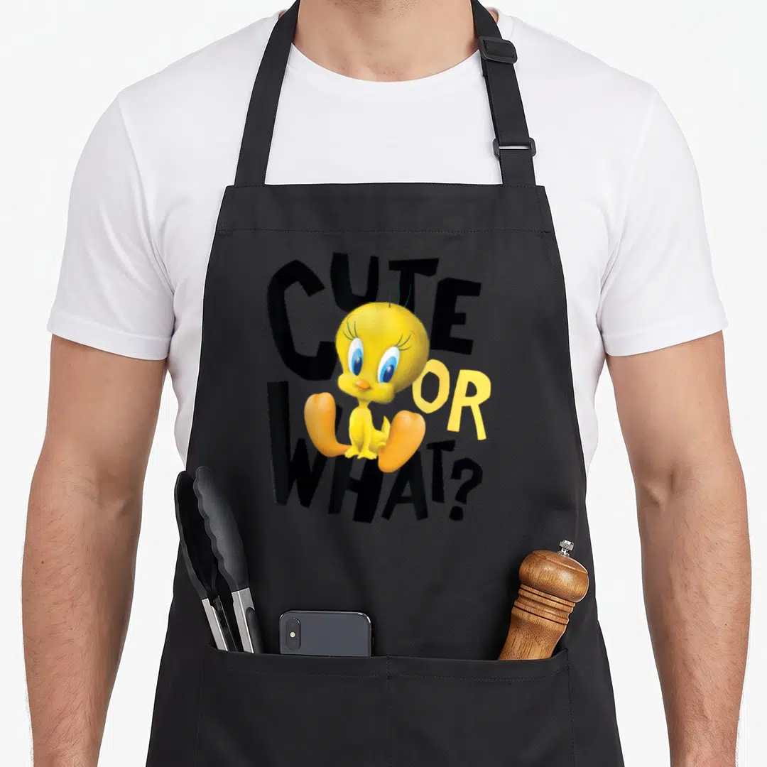 Tweety apron or apron - Yellow cartoon bird sitting over black CUTE OR WHAT? text — shown on a black cotton canvas apron against a white background