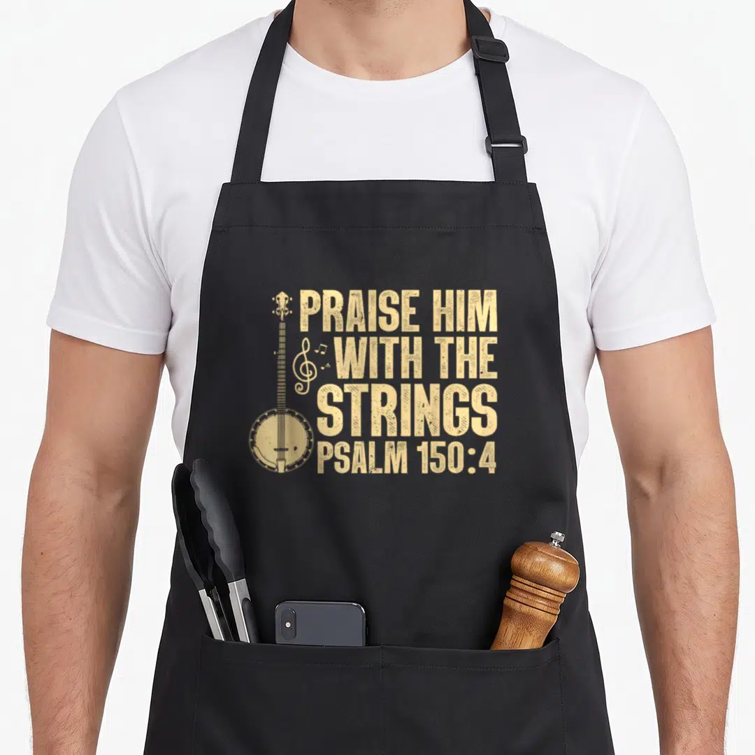 Worship banjo apron - Distressed tan banjo illustration next to stacked Praise Him With The Strings Psalm 150:4 text — shown on a black cotton canvas apron against a white background