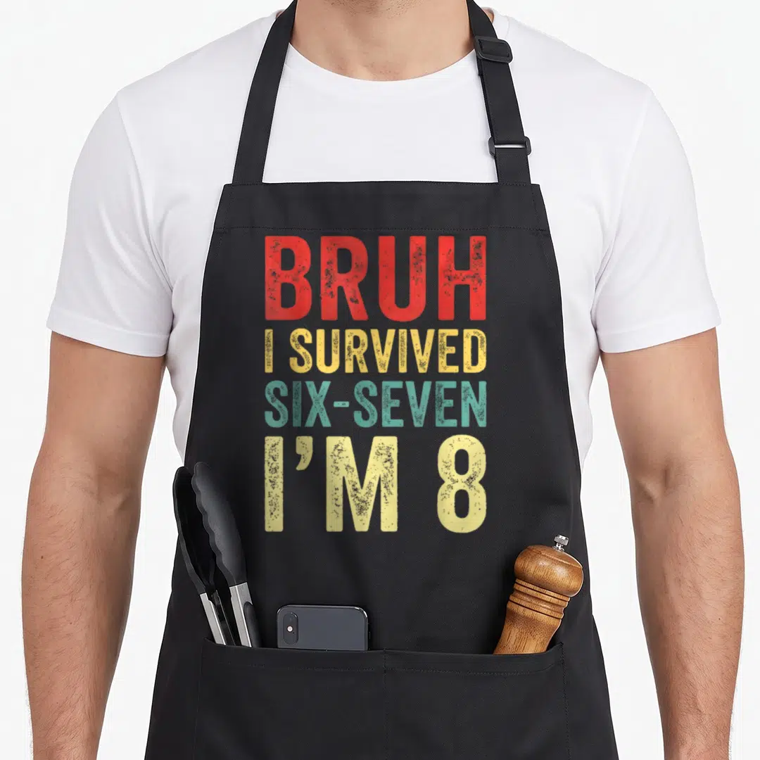 Survived birthday apron - Stacked BRUH I SURVIVED SIX-SEVEN I'M 8 text in red yellow teal distressed style — shown on a black cotton canvas apron against a white background